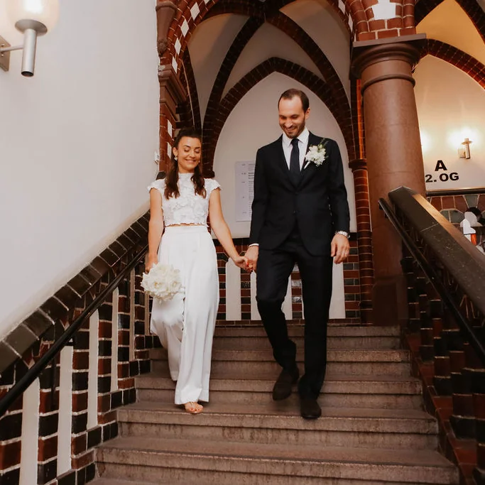 Bride and groom walking down a staircase together