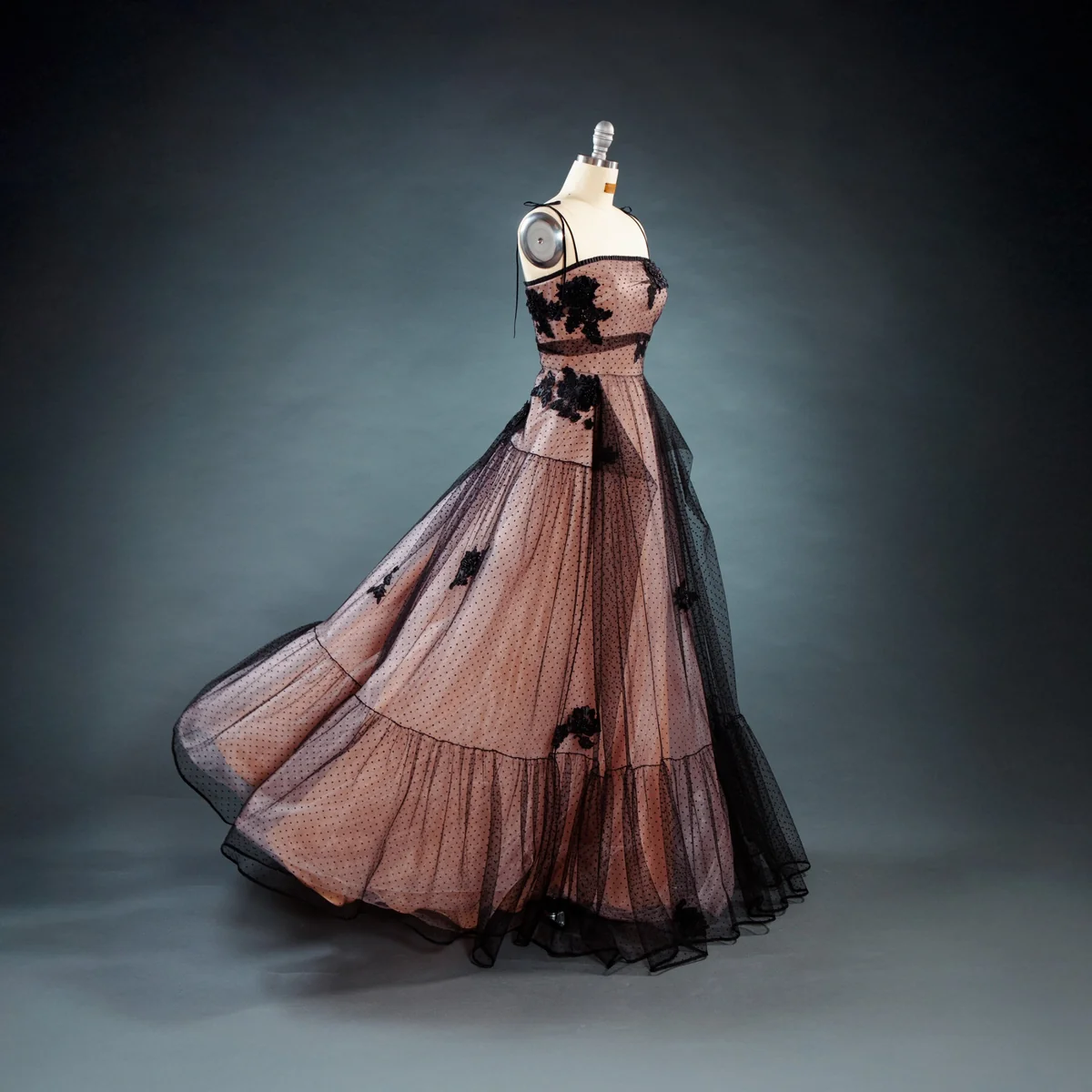 Roséfarbenes Abendkleid mit schwarzem Tüll und floralen Applikationen auf einer Schneiderpuppe